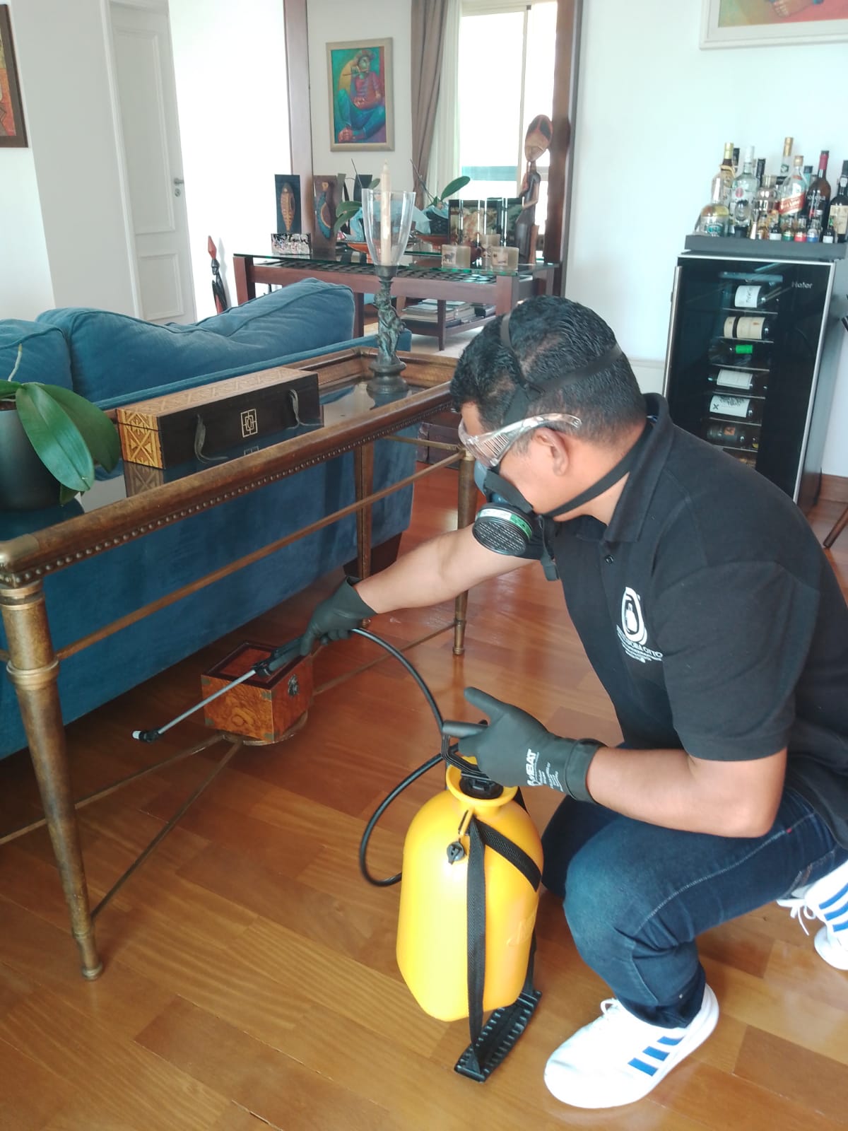 Homem dedetizando e aplicando produto de dedetização em local 