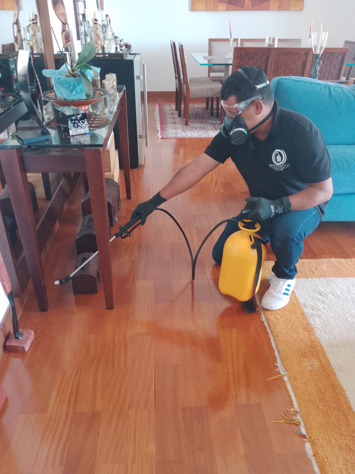 Homem dedetizando e aplicando produto de dedetização em local 